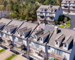 Morgantown, WV - 22 April 2020: Aerial view of roofing contractors replacing the old shingles on a townhouse roof