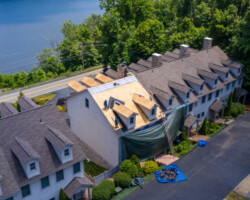 Morgantown, WV - 7 July 2020: Aerial view of roofing contractors replacing the old shingles on a townhouse roof