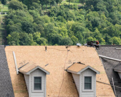 Roofing contractor has removed all the old tiles from townhouse roof before replacing with new shingles