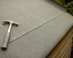 Replacing felt on a shed roof. Part of a series showing a roof being replaced on a shed in a UK garden.