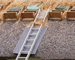 Partly completed re-roofing of a traditional English thatched cottage